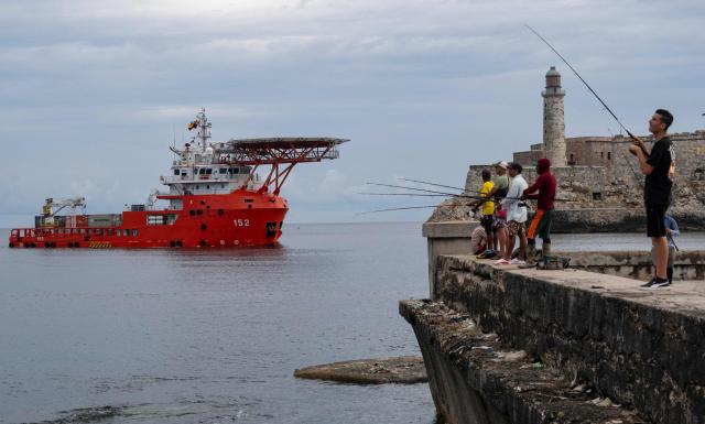 Men fish as the Colombian Navy ship ARC Caribe arrives in Cuba carrying humanitarian aid in Havana, on June 12, 2026.  (Photo by YAMIL LAGE / AFP)