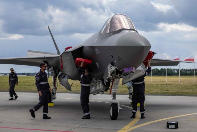 Ground crew is seen around one of the three US-made F-35 aircraft (Polish codename Husarz) in the Polish Air Force at the 32nd Tactical Air Base in Lask, central Poland, on June 12, 2026, on the day of their official entry into service with the Polish Air Force. (Photo by Wojtek RADWANSKI / AFP)
