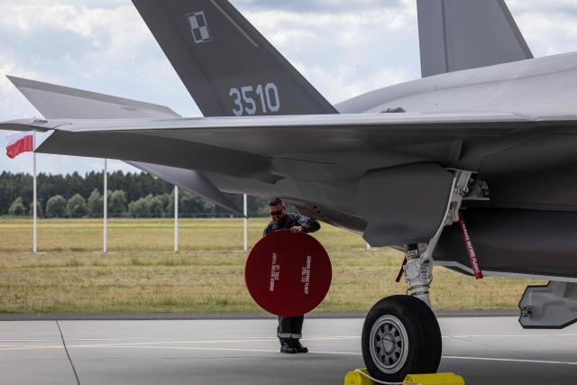 Ground crew is seen around one of the three US-made F-35 aircraft (Polish codename Husarz) in the Polish Air Force at the 32nd Tactical Air Base in Lask, central Poland, on June 12, 2026, on the day of their official entry into service with the Polish Air Force. (Photo by Wojtek RADWANSKI / AFP)