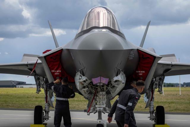 Ground crew is seen around one of the three US-made F-35 aircraft (Polish codename Husarz) in the Polish Air Force at the 32nd Tactical Air Base in Lask, central Poland, on June 12, 2026, on the day of their official entry into service with the Polish Air Force. (Photo by Wojtek RADWANSKI / AFP)