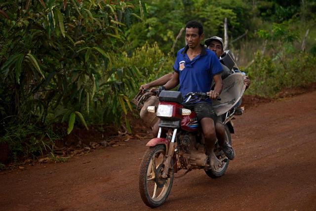 Miners ride a motorcycle carrying mining tools as they leave an artisanal gold mine in Las Brisas de Cuyuni, near the town of Las Claritas, Bolivar state, Venezuela, on June 11, 2026. Venezuela, home to the world's largest oil reserves, also has deposits of gold, diamonds, bauxite, coltan and rare earths, but much of its mining areas — notably the 112,000 sq km Mining Arc located in remote regions far from major cities — is controlled by armed gangs or guerrilla groups. (Photo by Federico PARRA / AFP)