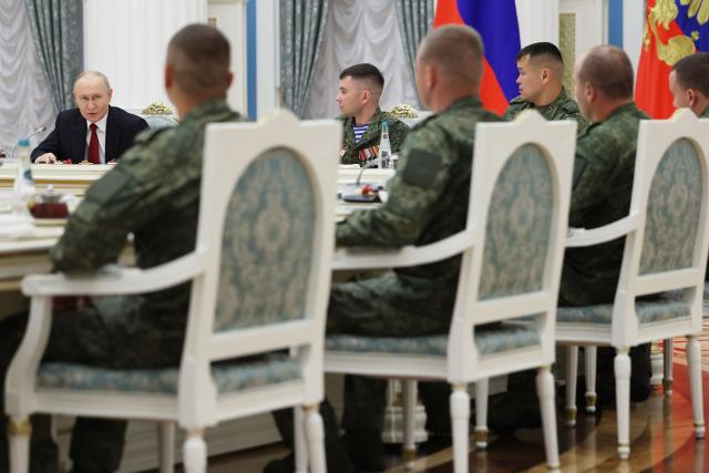 In this pool photograph distributed by the Russian state agency Sputnik, Russia's President Vladimir Putin (L) attends a meeting with Russian servicemen, involved in the so-called 'special military operation' in Ukraine, in Moscow on June 12, 2026. Ukrainian drone strikes, which have intensified in recent months, are aimed at “sowing division” within Russian society and “damaging” the economy, Vladimir Putin said on June 12, 2026, though he insisted that they “will not succeed”. (Photo by Viacheslav PROKOFIEV / POOL / AFP)