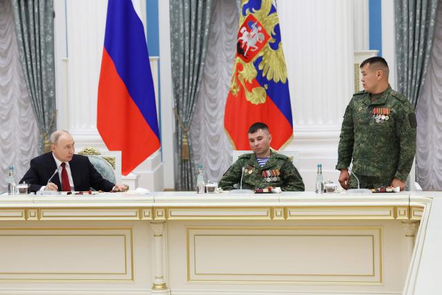 In this pool photograph distributed by the Russian state agency Sputnik, Russia's President Vladimir Putin (L) attends a meeting with Russian servicemen, involved in the so-called 'special military operation' in Ukraine, in Moscow on June 12, 2026. Ukrainian drone strikes, which have intensified in recent months, are aimed at “sowing division” within Russian society and “damaging” the economy, Vladimir Putin said on June 12, 2026, though he insisted that they “will not succeed”. (Photo by Viacheslav PROKOFIEV / POOL / AFP)