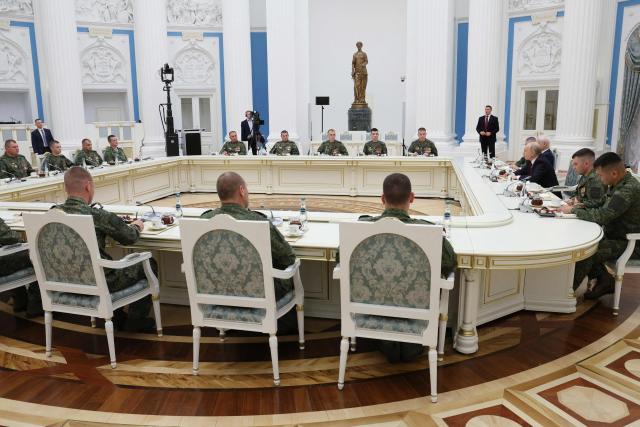 In this pool photograph distributed by the Russian state agency Sputnik, Russia's President Vladimir Putin (3rd R) attends a meeting with Russian servicemen, involved in the so-called 'special military operation' in Ukraine, in Moscow on June 12, 2026. Ukrainian drone strikes, which have intensified in recent months, are aimed at “sowing division” within Russian society and “damaging” the economy, Vladimir Putin said on June 12, 2026, though he insisted that they “will not succeed”. (Photo by Viacheslav PROKOFIEV / POOL / AFP)