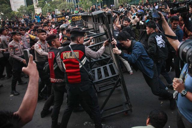 Police officers push back a barricade as university students protest against a steep rise in non-subsidised fuel prices and the government’s budget waste, urging authorities to halt the free school meals programme (MBG), in Jakarta on June 12, 2026. Hundreds of Indonesian students demonstrated in Jakarta on June 12 to demand the government correct its course as the Southeast Asian country grapples with worsening economic conditions. (Photo by Aditya Irawan / AFP)