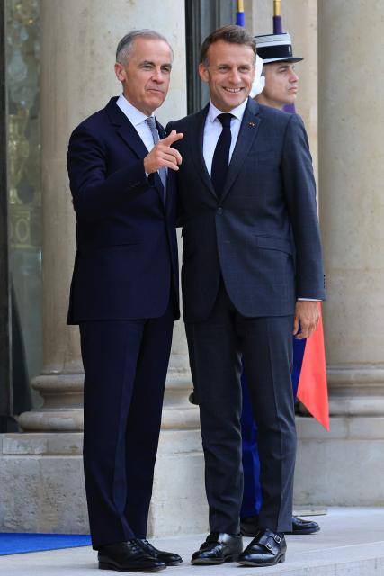 France's President Emmanuel Macron (R) poses with Canadian Prime Minister Mark Carney (L) as he welcomes him to The Elysee Presidential Palace ahead of a bilateral meeting, in Paris on June 12, 2026. (Photo by Ludovic MARIN / AFP)
