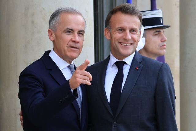 France's President Emmanuel Macron (R) poses with Canadian Prime Minister Mark Carney (L) as he welcomes him to The Elysee Presidential Palace ahead of a bilateral meeting, in Paris on June 12, 2026. (Photo by Ludovic MARIN / AFP)