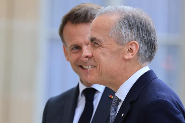 Canadian Prime Minister Mark Carney (R) is welcomed by France's President Emmanuel Macron (L) as he arrives at The Elysee Presidential Palace ahead of a bilateral meeting, in Paris on June 12, 2026. (Photo by Ludovic MARIN / AFP)