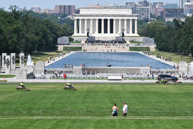 Workers mow grass near the area where the numbers "8647" appeared on the lawn on the National Mall in Washington, DC, on June 12, 2026. US Park Police opened an investigation on June 11 into giant markings of the numbers "8647" -- which have been associated with opposition to President Donald Trump -- on the grass of the National Mall. A spokesperson for the Department of the Interior, which manages the National Mall in downtown Washington, described the incident as "deranged vandalism" and said it "will not be tolerated." (Photo by Anne Lebreton / AFP)