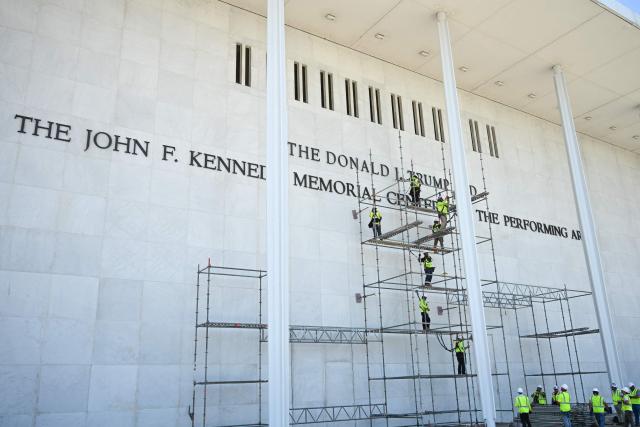Workers stand on scaffolding near the sign for the Donald J. Trump and John F. Kennedy Memorial Center for the Performing Arts in Washington, DC, on June 12, 2026. A US judge on May 29, 2026, ruled that the famed Kennedy Center for the Performing Arts had been illegally renamed after President Donald Trump and that his name must be taken down. (Photo by Alex WROBLEWSKI / AFP)
