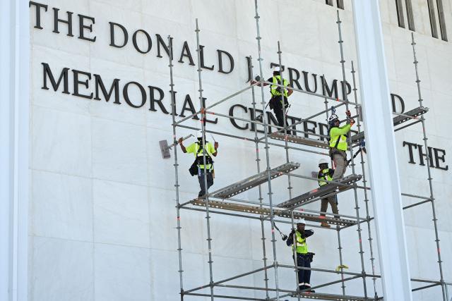 Workers stand on scaffolding near the sign for the Donald J. Trump and John F. Kennedy Memorial Center for the Performing Arts in Washington, DC, on June 12, 2026. A US judge on May 29, 2026, ruled that the famed Kennedy Center for the Performing Arts had been illegally renamed after President Donald Trump and that his name must be taken down. (Photo by Alex WROBLEWSKI / AFP)