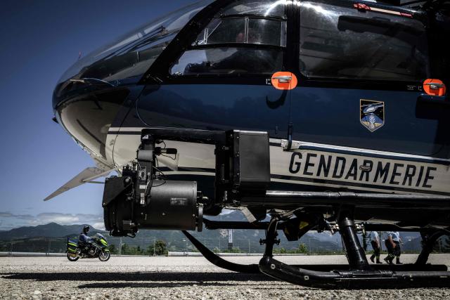 A member of the French gendarmerie rides his motorbike past a French gendarmerie helicopter during a security operations and patrol, on June 12, 2026 in La-Roche-sur-Foron ahead of the G7 Summit in Evian. (Photo by Jeff PACHOUD / AFP)