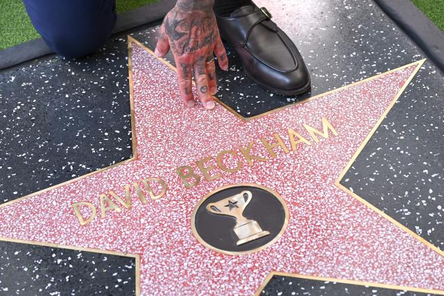 English former footballer David Beckham poses at his newly unveiled Hollywood Walk of Fame star during a ceremony in Hollywood, California, on June 12, 2026. (Photo by LISA O'CONNOR / AFP)