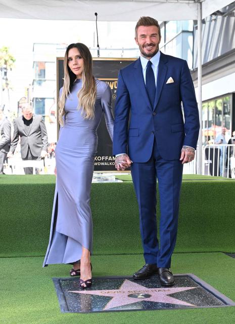 Victoria Beckham and her husband English former footballer David Beckham pose next to Beckham's newly unveiled Hollywood Walk of Fame star during a ceremony in Hollywood, California, on June 12, 2026. (Photo by LISA O'CONNOR / AFP)