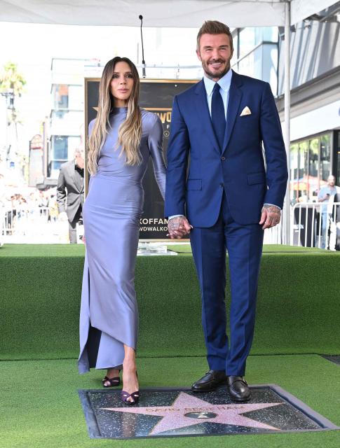 Victoria Beckham and her husband English former footballer David Beckham pose next to Beckham's newly unveiled Hollywood Walk of Fame star during a ceremony in Hollywood, California, on June 12, 2026. (Photo by LISA O'CONNOR / AFP)
