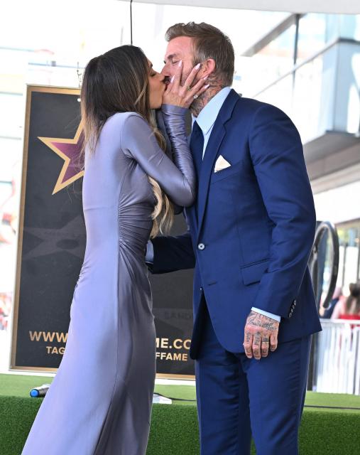 Victoria Beckham kisses her husband English former footballer David Beckham during his Hollywood Walk of Fame star ceremony in Hollywood, California, on June 12, 2026. (Photo by LISA O'CONNOR / AFP)