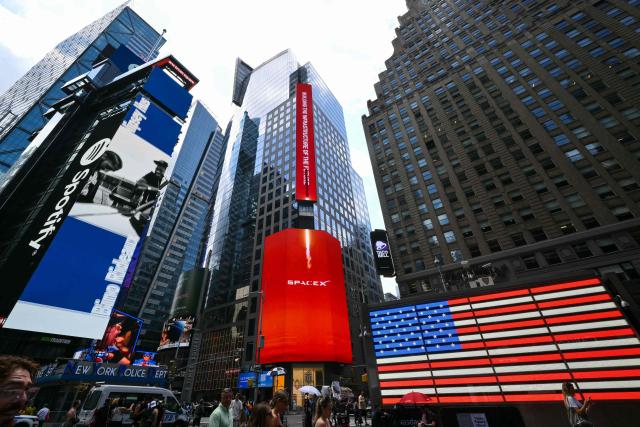 SpaceX advertisements are seen on a digital billboard at the Nasdaq MarketSite in Times Square to celebrate the launch of SpaceXs initial public offering (IPO) in New York on June 12, 2026. Elon Musk's SpaceX begins trading on the Nasdaq exchange on Friday with the biggest initial public offering in history expected to make the polarizing entrepreneur the world's first trillionaire. The company priced more than 555 million shares at $135 each in a filing with the US markets regulator on Thursday, placing SpaceX in the top 10 of Wall Street's biggest companies with a valuation of just under $1.8 trillion -- ahead of Tesla, Facebook-owner Meta and Walmart. (Photo by ANGELA WEISS / AFP)