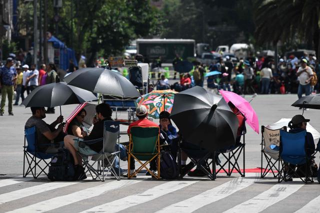 Teachers from the National Coordinator of Education Workers (CNTE) sit at a barricade blocking major avenues during a day of protest demanding better employment benefits in Mexico City on June 12, 2026. Teachers, along with students from the Ayotzinapa co-ed rural school and groups searching for missing persons, have been staging ongoing protests against the FIFA 2026 World Cup. (Photo by Yuri CORTEZ / AFP)