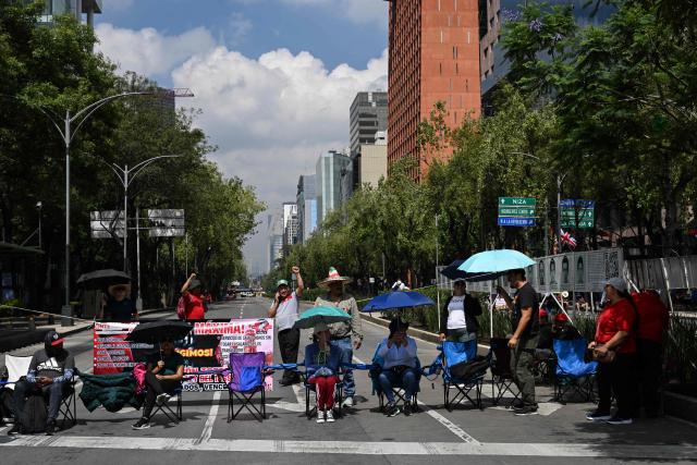 Teachers from the National Coordinator of Education Workers (CNTE) remain at a barricade blocking major avenues during a day of protest demanding better employment benefits in Mexico City on June 12, 2026. Teachers, along with students from the Ayotzinapa co-ed rural school and groups searching for missing persons, have been staging ongoing protests against the FIFA 2026 World Cup. (Photo by Yuri CORTEZ / AFP)
