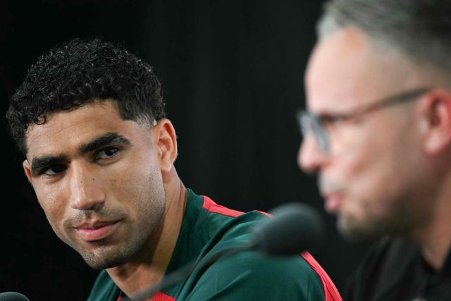 Morocco's defender #02 Achraf Hakimi gestures as head coach Mohamed Ouahbi speaks during a press conference at the New York/New Jersey Stadium in East Rutherford on June 12, 2026, on the eve of the 2026 World Cup football match between Brazil and Morocco. (Photo by Mauro PIMENTEL / AFP)