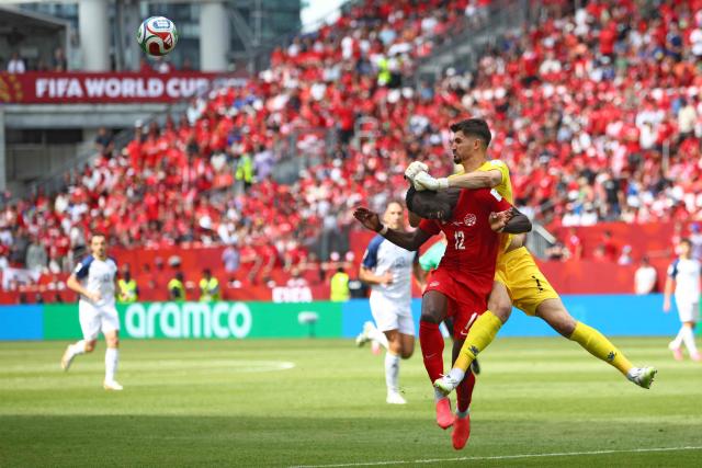 Bosnia-Herzegovina's goalkeeper #01 Nikola Vasilj (R) boxes the ball in front of Canada's forward #12 Tani Oluwaseyi during the 2026 World Cup Group B football match between Canada and Bosnia and Herzegovina at the Toronto Stadium in Toronto on June 12, 2026. (Photo by Cole Burston / AFP)