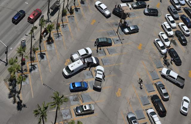 Forensic workers inspect a car (C) where a body was allegedly found at a parking lot close to Caliente stadium, where Iran's national football team trains, in Tijuana, Baja California, Mexico on June 12, 2026. (Photo by Guillermo Arias / AFP)