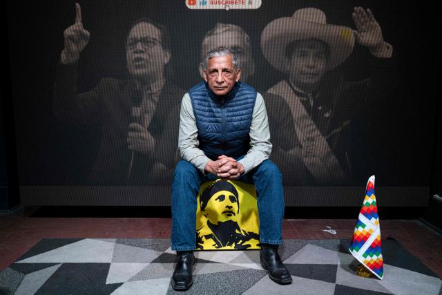 Antauro Humala, leader and founder of the Ethnocacerist party and promoter of Peruvian ultranationalism, poses for a picture in front of an image of Peru's presidential candidate Roberto Sanchez (L) and former Peruvian president Pedro Castillo during an interview with AFP at the Ethnocacerist party headquarters in Lima on June 12, 2026. Peru is heading toward a deeper governance crisis and protests if right-wing candidate Keiko Fujimori prevails over leftist Roberto Sanchez in the tight presidential vote count, nationalist leader Antauro Humala told AFP on June 12. (Photo by Ernesto BENAVIDES / AFP)