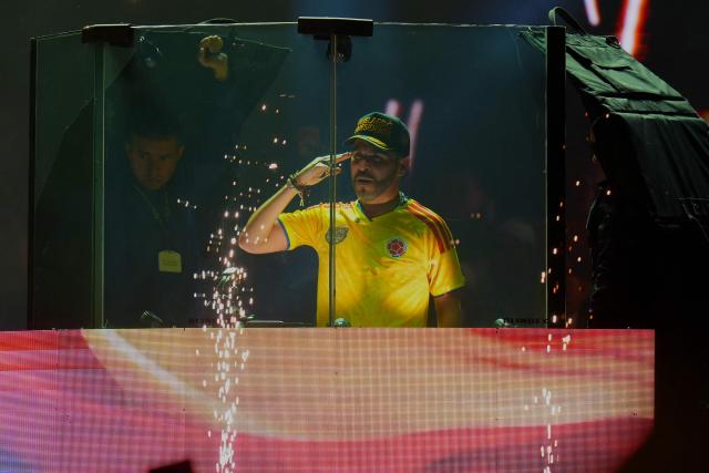 (FILES) Colombia's presidential candidate for the Defensores de la Patria party, Abelardo de la Espriella, salutes behind a bulletproof glass during his last campaign rally in Barranquilla, Colombia on May 23, 2026. The Colombian Supreme Court of Justice suspended on June 12, 2026 a lower court’s ruling that had banned far-right presidential candidate Abelardo de la Espriella from using national symbols and his signature slogan, “Firm for the homeland”. The 47-year-old lawyer often uses the military salute of the armed forces and national insignia at political rallies, which are filled with Colombian flags and national football team shirts. Colombia will hold the runoff presidential election on June 21. (Photo by Vanessa ROMERO / AFP)