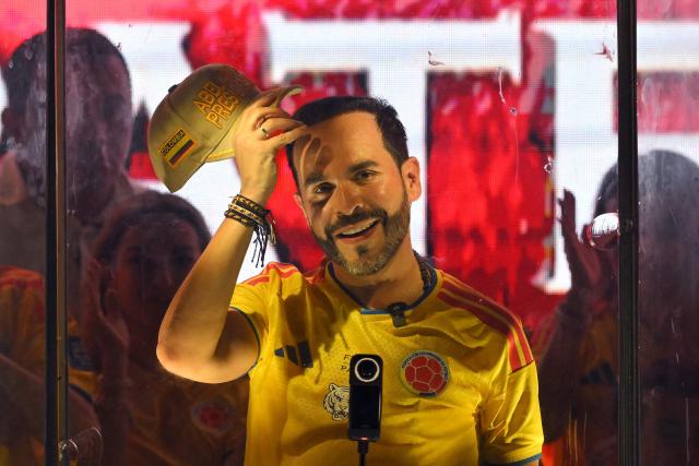 (FILES) Colombia's presidential candidate Abelardo de la Espriella, of the Salvadores de la Patria movement, gestures as he speaks to supporters behind bulletproof glass after a quick count of votes in the presidential election at the Ventana al Mundo monument in Barranquilla, Colombia, on May 31, 2026. The Colombian Supreme Court of Justice suspended on June 12, 2026 a lower court’s ruling that had banned far-right presidential candidate Abelardo de la Espriella from using national symbols and his signature slogan, “Firm for the homeland”. The 47-year-old lawyer often uses the military salute of the armed forces and national insignia at political rallies, which are filled with Colombian flags and national football team shirts. Colombia will hold the runoff presidential election on June 21. (Photo by Rodrigo BUENDIA / AFP)