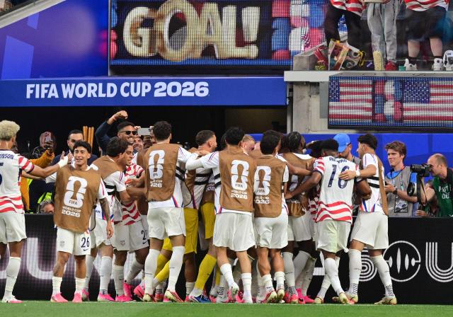 US players celebrate the third goal by forward #20 Folarin Balogun during the 2026 World Cup Group D football match between USA and Paraguay at the Los Angeles Stadium in Inglewood on June 12, 2026. (Photo by Frederic J. BROWN / AFP)