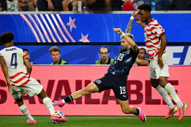 Paraguay's midfielder #19 Julio Enciso (C) fights for the ball past US defender #16 Alex Freeman (R) during the 2026 World Cup Group D football match between USA and Paraguay at the Los Angeles Stadium in Inglewood on June 12, 2026. (Photo by Patrick T. Fallon / AFP)