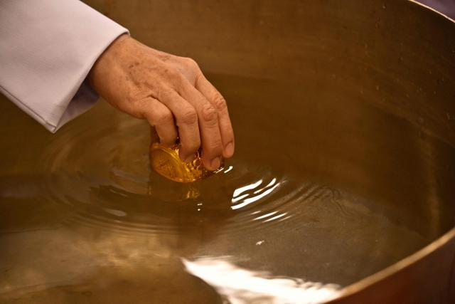 An official dips a cup while paying respects in front of a portrait of the late Princess Thai Princess Bajrakitiyabha Mahidol at the palace in Bangkok on June 13, 2026. Thai Princess Bajrakitiyabha Mahidol, the king's eldest daughter, has died aged 47, the royal palace announced on June 12, more than three years after she was hospitalised following a sudden illness. (Photo by ANTHONY WALLACE / AFP)