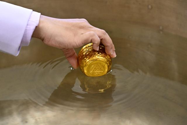 An official dips a cup while paying respects in front of a portrait of the late Princess Thai Princess Bajrakitiyabha Mahidol at the palace in Bangkok on June 13, 2026. Thai Princess Bajrakitiyabha Mahidol, the king's eldest daughter, has died aged 47, the royal palace announced on June 12, more than three years after she was hospitalised following a sudden illness. (Photo by ANTHONY WALLACE / AFP)
