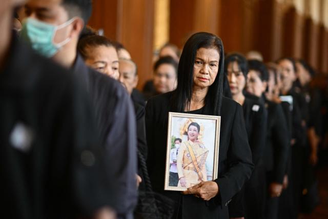 A mourner holds a portrait of the late Thai Princess Bajrakitiyabha Mahidol at the palace in Bangkok on June 13, 2026. Thai Princess Bajrakitiyabha Mahidol, the king's eldest daughter, has died aged 47, the royal palace announced on June 12, more than three years after she was hospitalised following a sudden illness. (Photo by ANTHONY WALLACE / AFP)