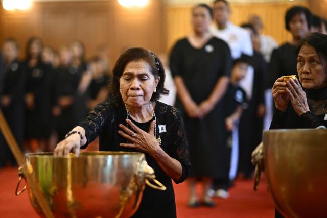 A member of the public dips a cup while paying respects in front of a portrait of the late Thai Princess Bajrakitiyabha Mahidol in the royal throne hall at the Grand Palace in Bangkok on June 13, 2026. Thai Princess Bajrakitiyabha Mahidol, the king's eldest daughter, has died aged 47, the royal palace announced on June 12, more than three years after she was hospitalised following a sudden illness. (Photo by ANTHONY WALLACE / AFP)