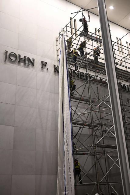 Workers build scaffolding near the signage for the "Donald J. Trump and John F. Kennedy Memorial Center for the Performing Arts" in Washington, DC, early on June 13, 2026. A US federal judge on June 12 rejected a bid by the board of the Kennedy Center and the Justice Department to halt the removal of President Donald Trump's name from the performing arts venue. District Judge Christopher Cooper, in a ruling last month, ordered Trump's name taken off the iconic building in the nation's capital by Friday, June 12, 2026. (Photo by Alex WROBLEWSKI / AFP)