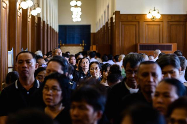 Members of the public line up to pay respects in front of a portrait of the late Thai Princess Bajrakitiyabha Mahidol in the royal throne hall at the Grand Palace in Bangkok on June 13, 2026. Hundreds of black-clad Thai mourners gathered at the royal palace in Bangkok on June 13, awaiting the arrival of the body of the king's eldest daughter a day after her death was announced. (Photo by ANTHONY WALLACE / AFP)