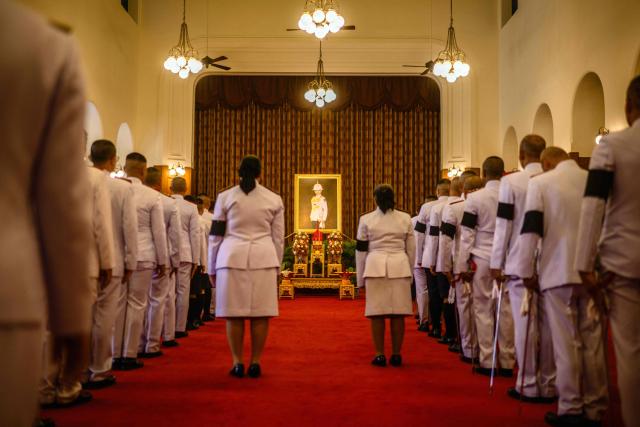 Officials line up to pay respects in front of a portrait of the late Thai Princess Bajrakitiyabha Mahidol in the royal throne hall at the Grand Palace in Bangkok on June 13, 2026. Hundreds of black-clad Thai mourners gathered at the royal palace in Bangkok on June 13, awaiting the arrival of the body of the king's eldest daughter a day after her death was announced. (Photo by ANTHONY WALLACE / AFP)