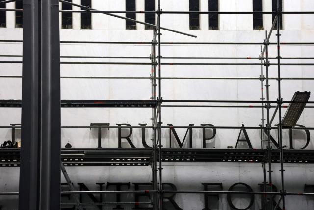 Scaffolding stands near the signage for the "Donald J. Trump and John F. Kennedy Memorial Center for the Performing Arts" in Washington, DC, on June 13, 2026. A US federal judge on June 12 rejected a bid by the board of the Kennedy Center and the Justice Department to halt the removal of President Donald Trump's name from the performing arts venue. (Photo by Alex WROBLEWSKI / AFP)