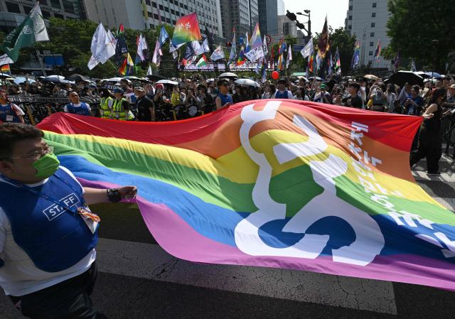 Staff members carry a huge flag during a Pride event in support of LGBTQ rights as part of the Seoul Queer Culture Festival in Seoul on June 13, 2026. (Photo by Jung Yeon-je / AFP)