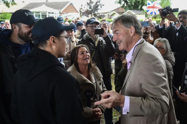 Restore Britain leader Rupert Lowe (R) and Restore Britain candidate Rebecca Shepherd (C) meet with volunteers before campaigning ahead of the Makerfield by-election on June 18, west of Manchester, north-west England on June 13, 2026. (Photo by PETER POWELL / AFP)