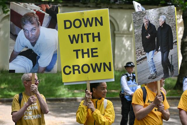 Protestors hold placards showing Britain's former Prince Andrew and late US sex offender Jeffrey Epstein during the King's Birthday Parade "Trooping the Colour" in London on June 13, 2026. (Photo by JUSTIN TALLIS / AFP)