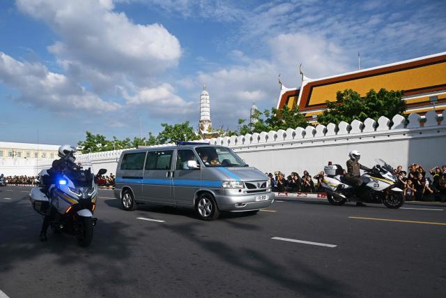 A hearse arrives at the Grand Palace carrying the body of Thai Princess Bajrakitiyabha Mahidol as mourners line the motorcade route, where funeral rites will begin for the late princess, in Bangkok on June 13, 2026. Hundreds of black-clad Thai mourners gathered at the royal palace in Bangkok on June 13, awaiting the arrival of the body of the king's eldest daughter a day after her death was announced. (Photo by ANTHONY WALLACE / AFP)