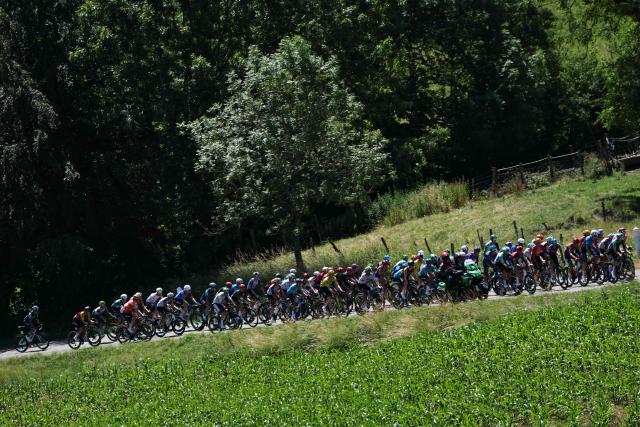 The pack of riders (peloton) cycles during the 7th stage of the Tour Auvergne-Rhone-Alpes cycling race (formerly known as the Criterium du Dauphine), 133,6km between La Bridoire and Grand Colombier in the French Alps on June 13, 2026. (Photo by Anne-Christine POUJOULAT / AFP)