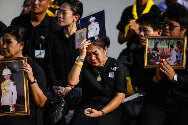Mourners react after the hearse carrying the body of Thai Princess Bajrakitiyabha Mahidol drives past, outside the Grand Palace, where funeral rites will begin for the late princess, in Bangkok on June 13, 2026. Hundreds of black-clad Thai mourners gathered at the royal palace in Bangkok on June 13, awaiting the arrival of the body of the king's eldest daughter a day after her death was announced. (Photo by ANTHONY WALLACE / AFP)