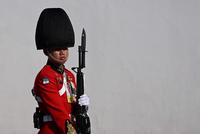 A soldier waits for the hearse carrying the body of Thai Princess Bajrakitiyabha Mahidol to arrive, in front of the Grand Palace where funeral rites will begin for the late princess, in Bangkok on June 13, 2026. Hundreds of black-clad Thai mourners gathered at the royal palace in Bangkok on June 13, awaiting the arrival of the body of the king's eldest daughter a day after her death was announced. (Photo by Lillian SUWANRUMPHA / AFP)