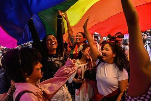 Supporters and members of the LGBTQ community carry a rainbow flag as they take part in a Pride Parade in Kathmandu on June 13, 2026. (Photo by Prakash MATHEMA / AFP)