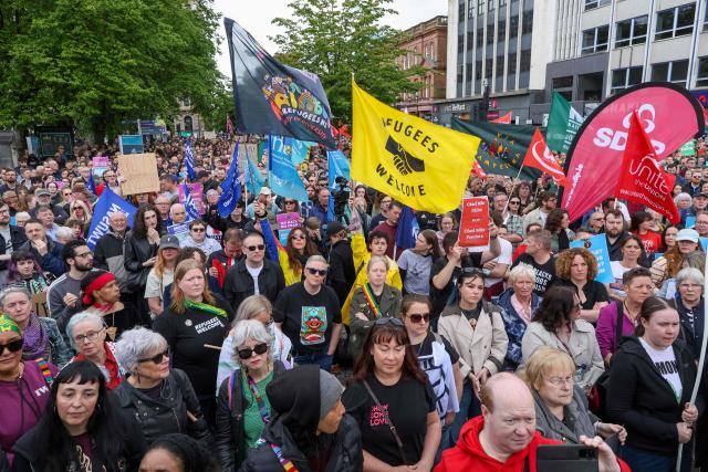 People turn out for a demonstration against racism and call for calm in central Belfast, Northern Ireland on June 13, 2026, after a few nights of disorder hit the city when video of a knife attack on June 8 went viral across social media platforms. Thousands of people on June 13 gathered for an anti-racism rally in the Northern Irish city of Belfast after unrest sparked by a horrific stabbing. (Photo by Paul Faith / AFP)
