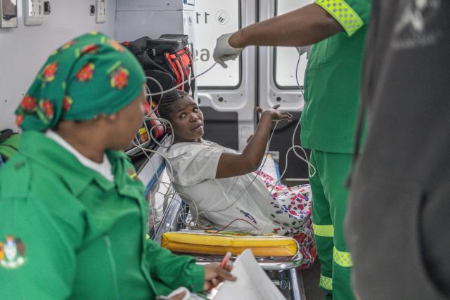 Paramedics tend to a pregnant migrant and transport her to a local hospital after she complained of extreme pain at Sherwood Park in Durban on June 13, 2026 after fleeing their homes amid fears of xenophobic attacks. Hundreds of migrants await repatriation to Malawi from South Africa following xenophobic violence in the country. (Photo by RAJESH JANTILAL / AFP)