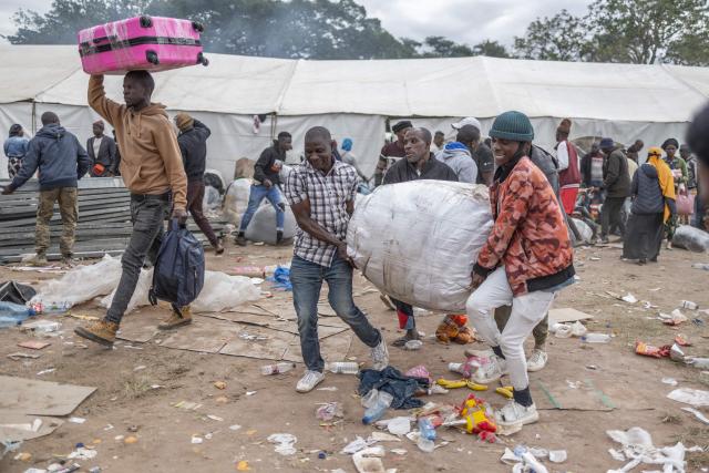 Displaced migrants gathered at Sherwood Park in Durban on June 13, 2026 carry their belongings as they wait to be repatriated to Malawi after fleeing their homes amid fears of xenophobic attacks. Hundreds of migrants await repatriation to Malawi from South Africa following xenophobic violence in the country. (Photo by RAJESH JANTILAL / AFP)